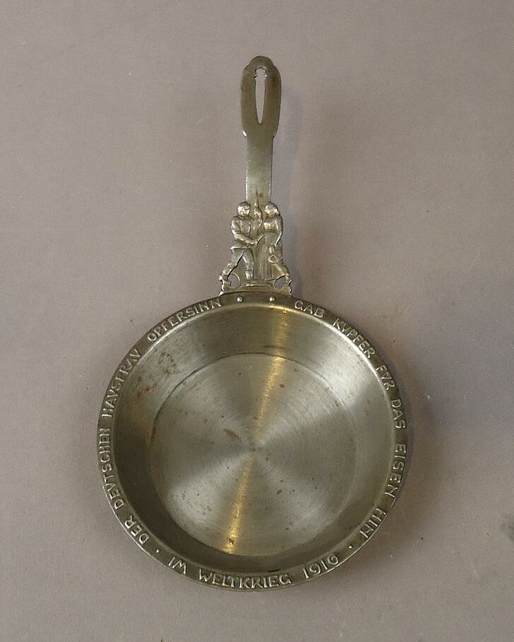 Silberne Pfanne mit eingraviertem Text.