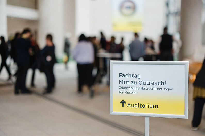 Ein Schild mit der Aufschrift "Fachtag" vor einer Menschenmenge