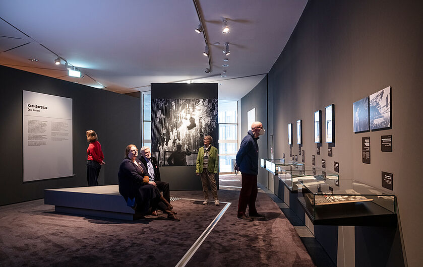 Personen schauen sich die Ausstellung an.
