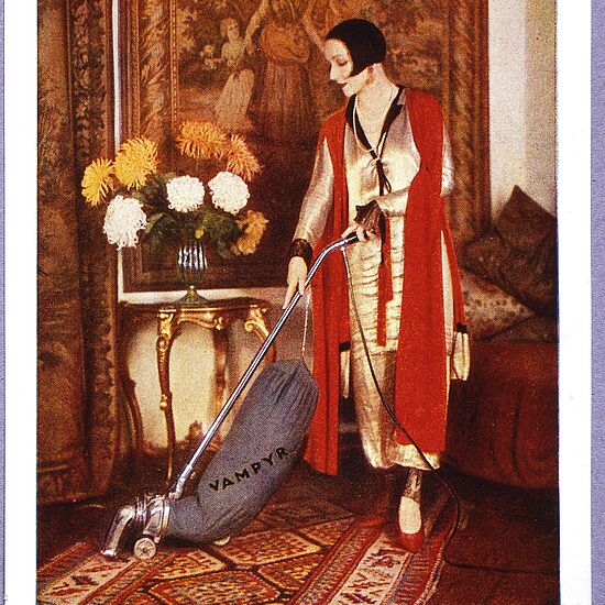 Eine Frau mit Staubsauger in der Hand.