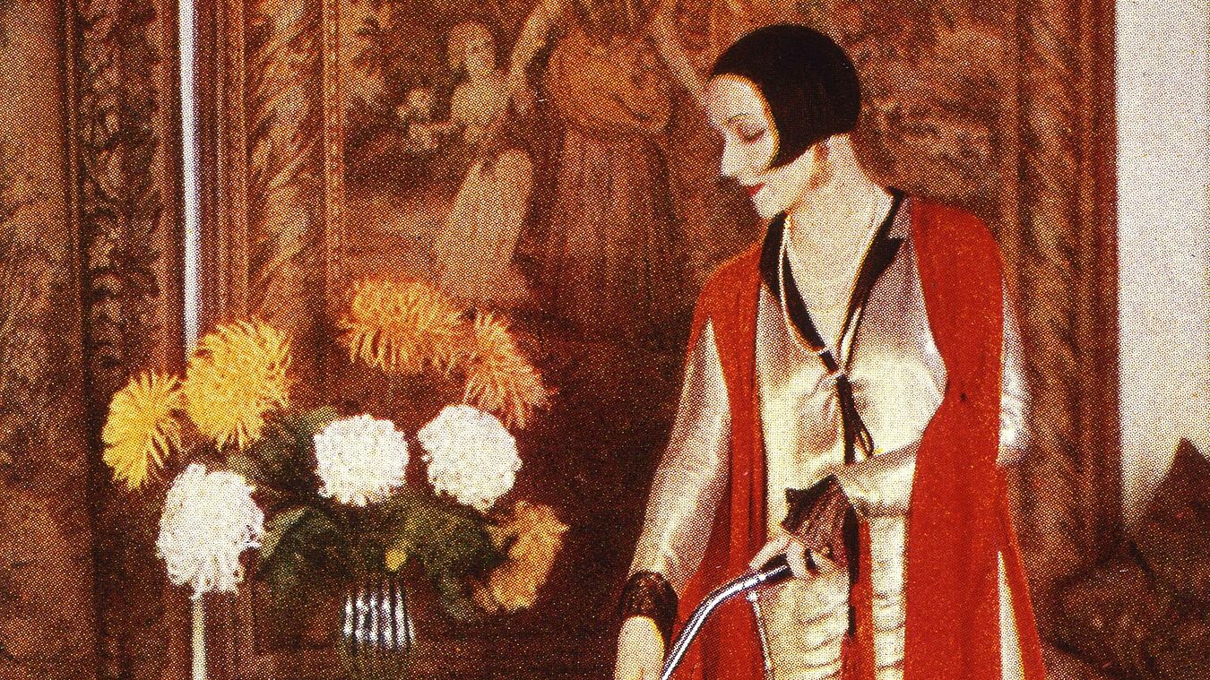 Eine Frau mit Staubsauger in der Hand.