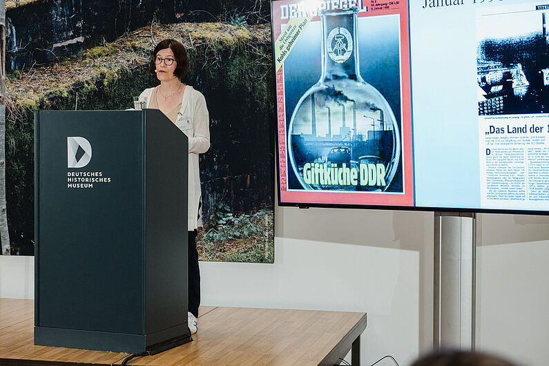 Astrid M. Eckert steht an einem Pult und spricht zum Publikum.