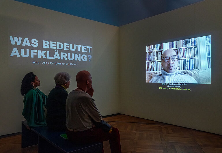 Drei Personen sehen sich ein Video an.