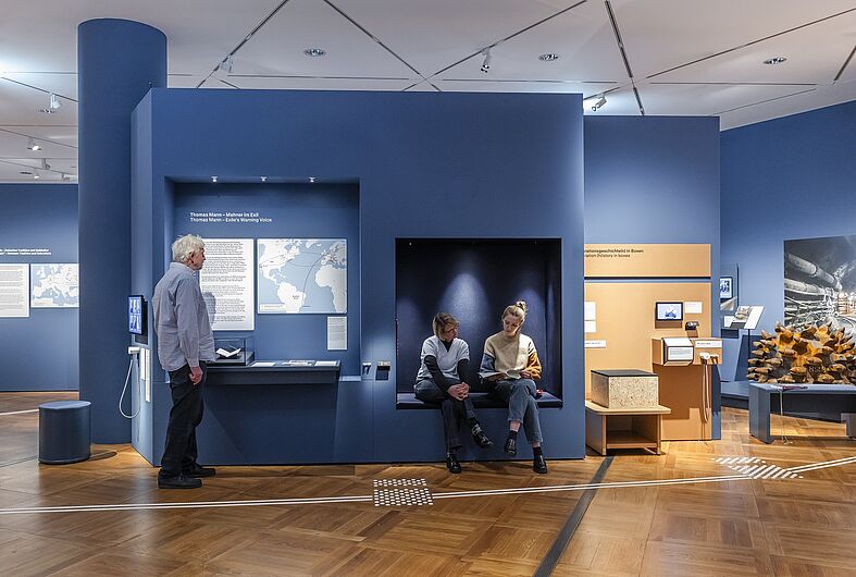 Menschen stehen in einer Ausstellung