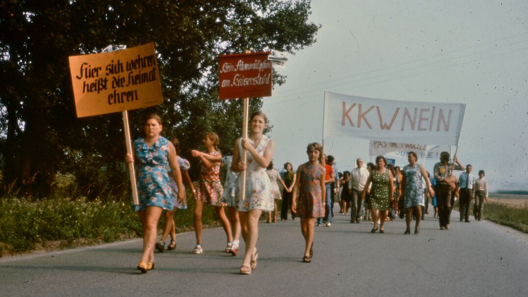Eine Gruppe von Frauen läuft auf einer Straße. Einige Frauen tragen bemalte Schilder in der Hand.