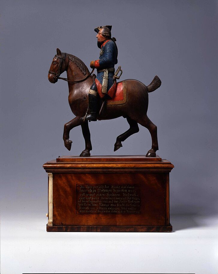 Tabaklade mit Reiterstatuette.