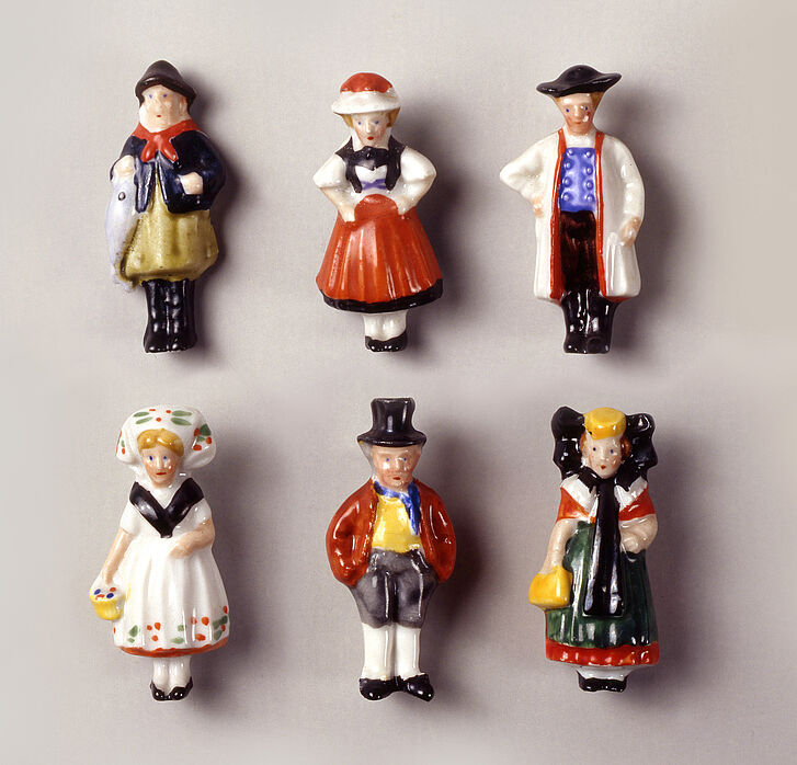 Sechs Figuren in volkstümlicher Kleidung.