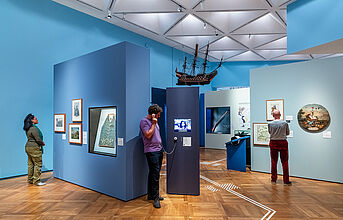 Personen schauen sich die Ausstellung an.