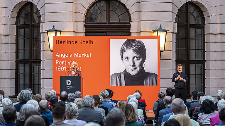 Eine Frau spricht vor Publikum.