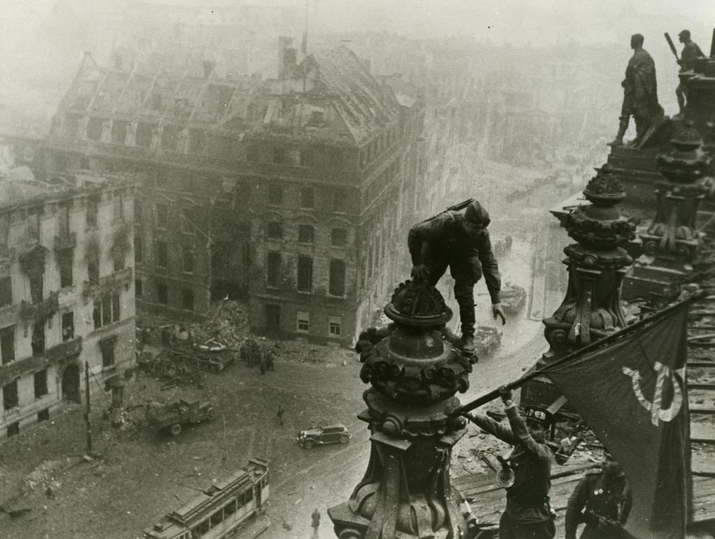 Foto: Rotarmisten mit sowjetischer Fahne auf dem Reichstag, 1945