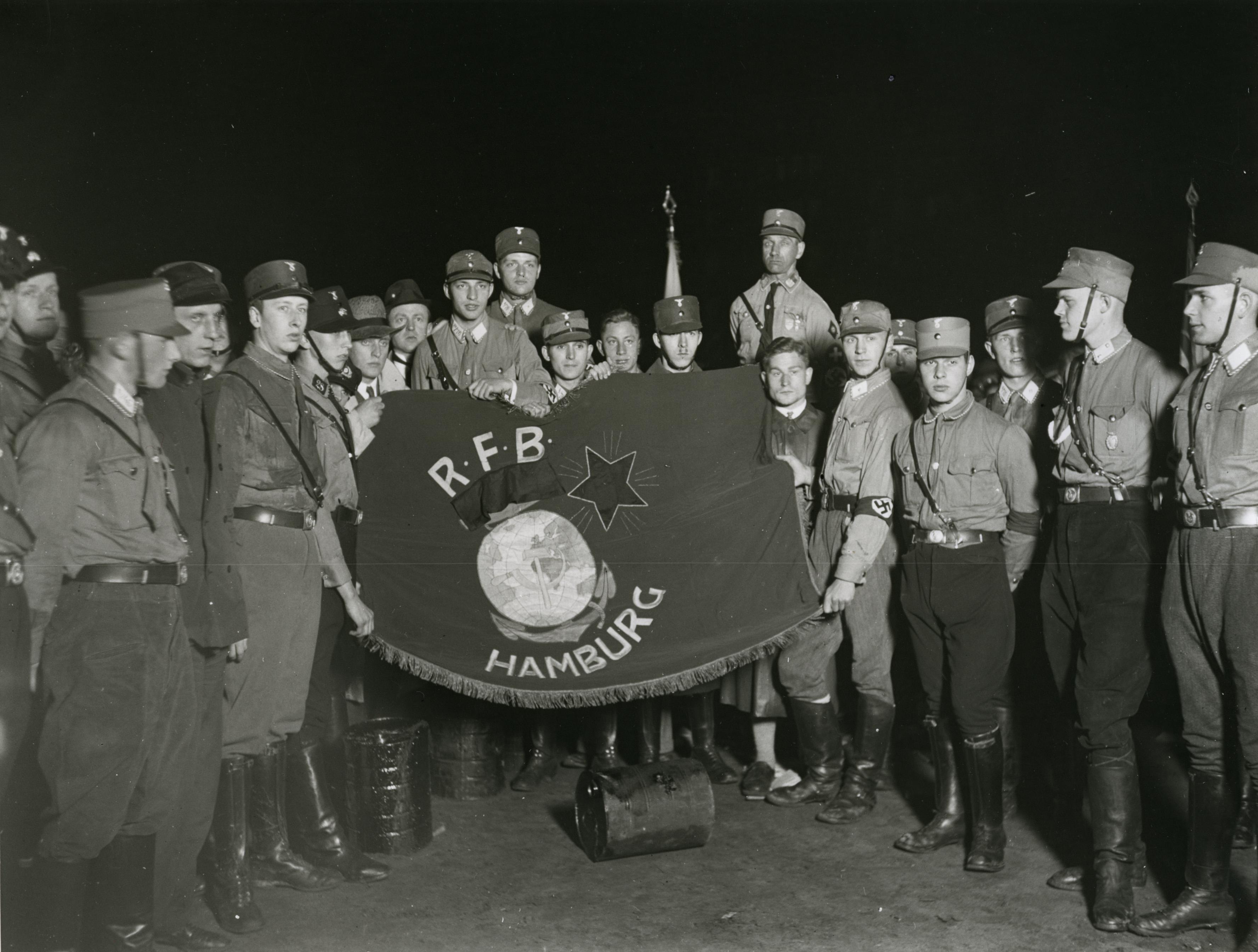 Mitglieder der Hamburger SA mit erbeuteter Fahne des Roten Frontkämpferbundes, 1931/1933