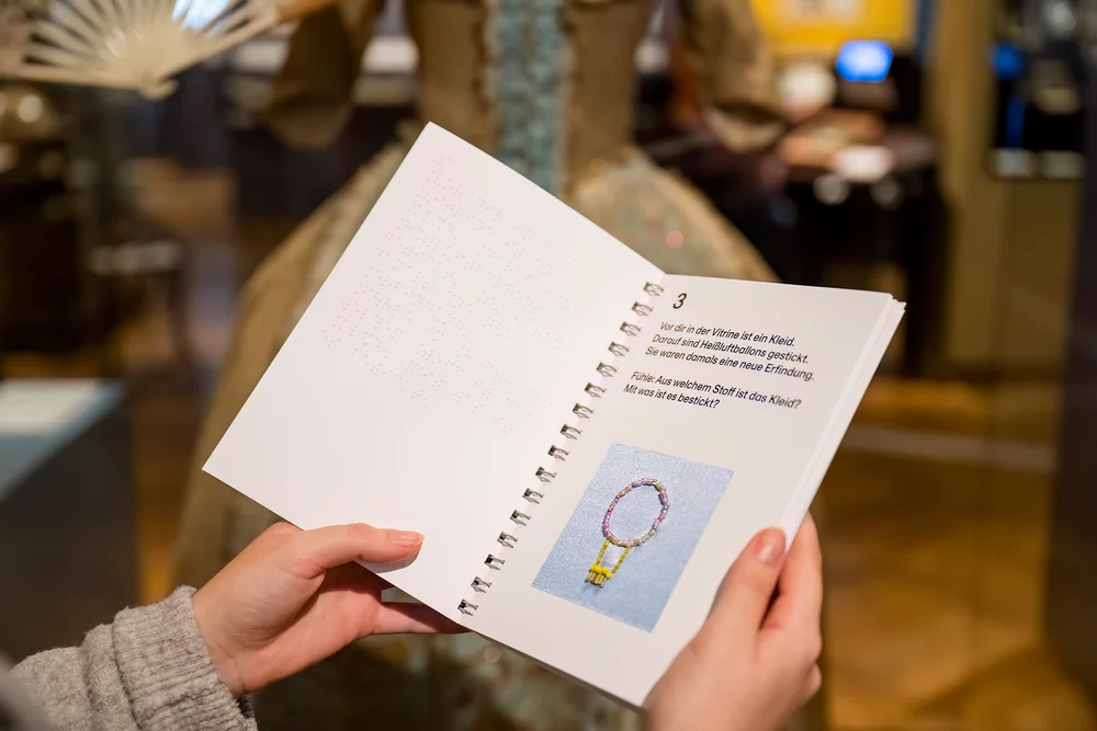 A person is holding an open notebook in their hand