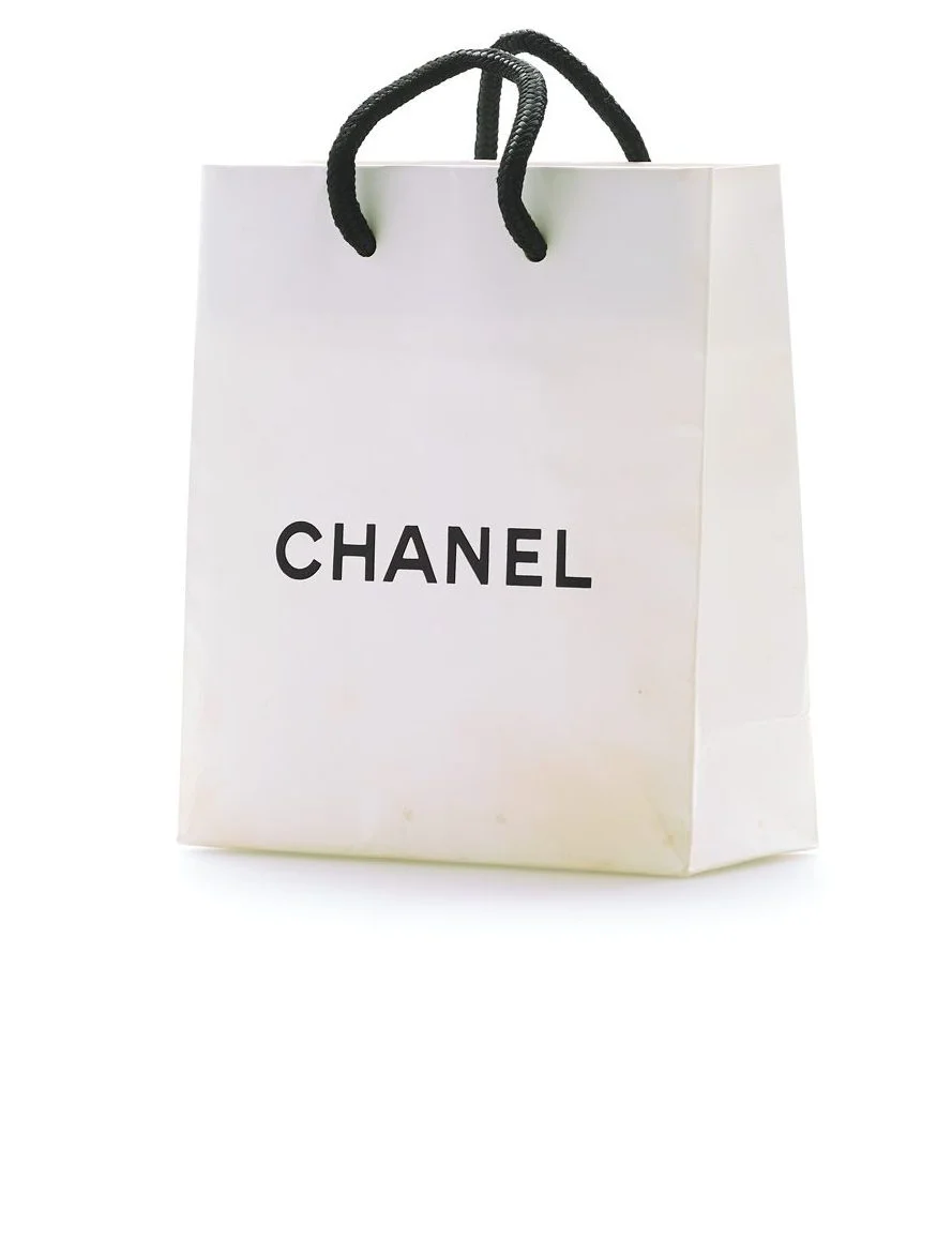 white Chanel shopping bag with the black Chanel Logo in the middle