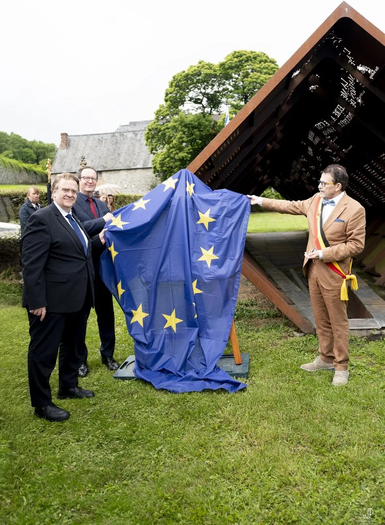 Das Foto zeigt die Rückgabezeremonie des Bronzereliefs von Frans Huygelen „Zur Erinnerung an Dinant“ am 12.6.2026 in Dinant. Von links nach rechts sind zu sehen  der Botschafter der Bundesrepublik Deutschland beim Königreich Belgien Martin Kotthaus, DHM-Präsident Raphael Gross und der Bürgermeister von Dinant Richard Fournaux.  