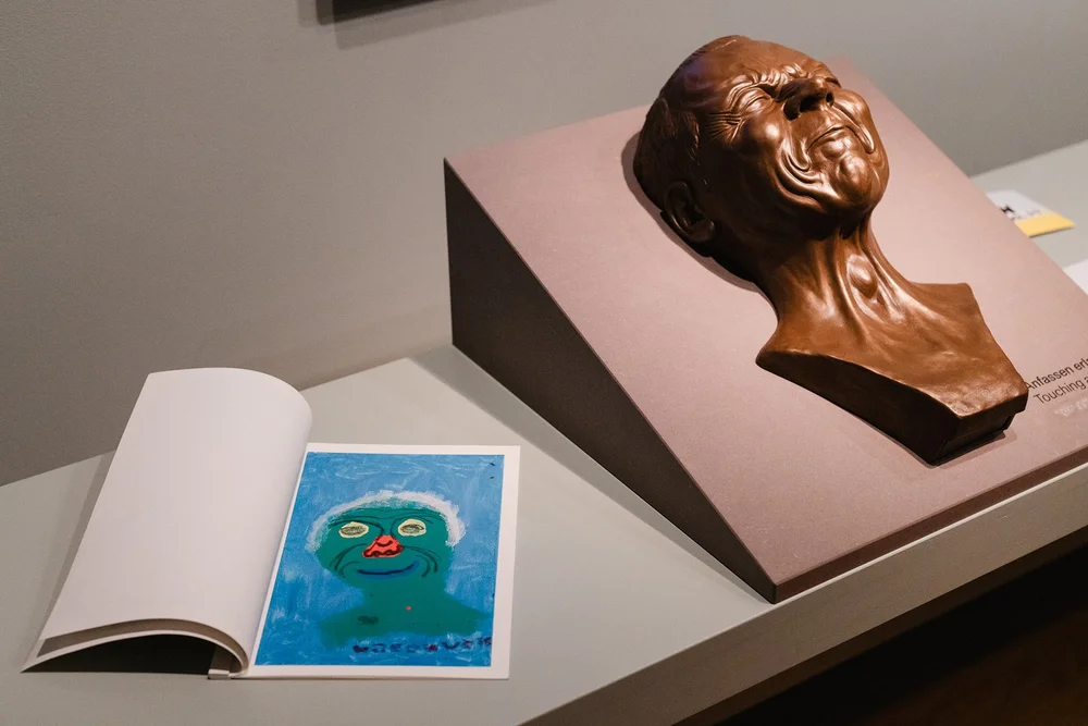 A painting by a pupil and a tactile model of a character’s head