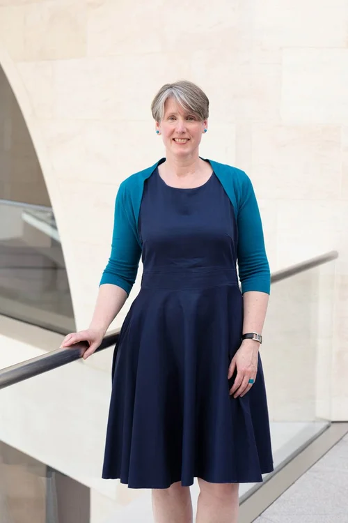 Portraitfoto von Sabine Witt in einem blauen Kleid. 
