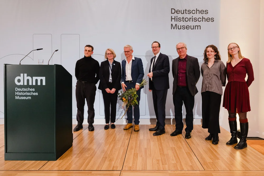 Das Ausstellungsteam und Präsident Raphael Gross auf der Bühne mit Blumen